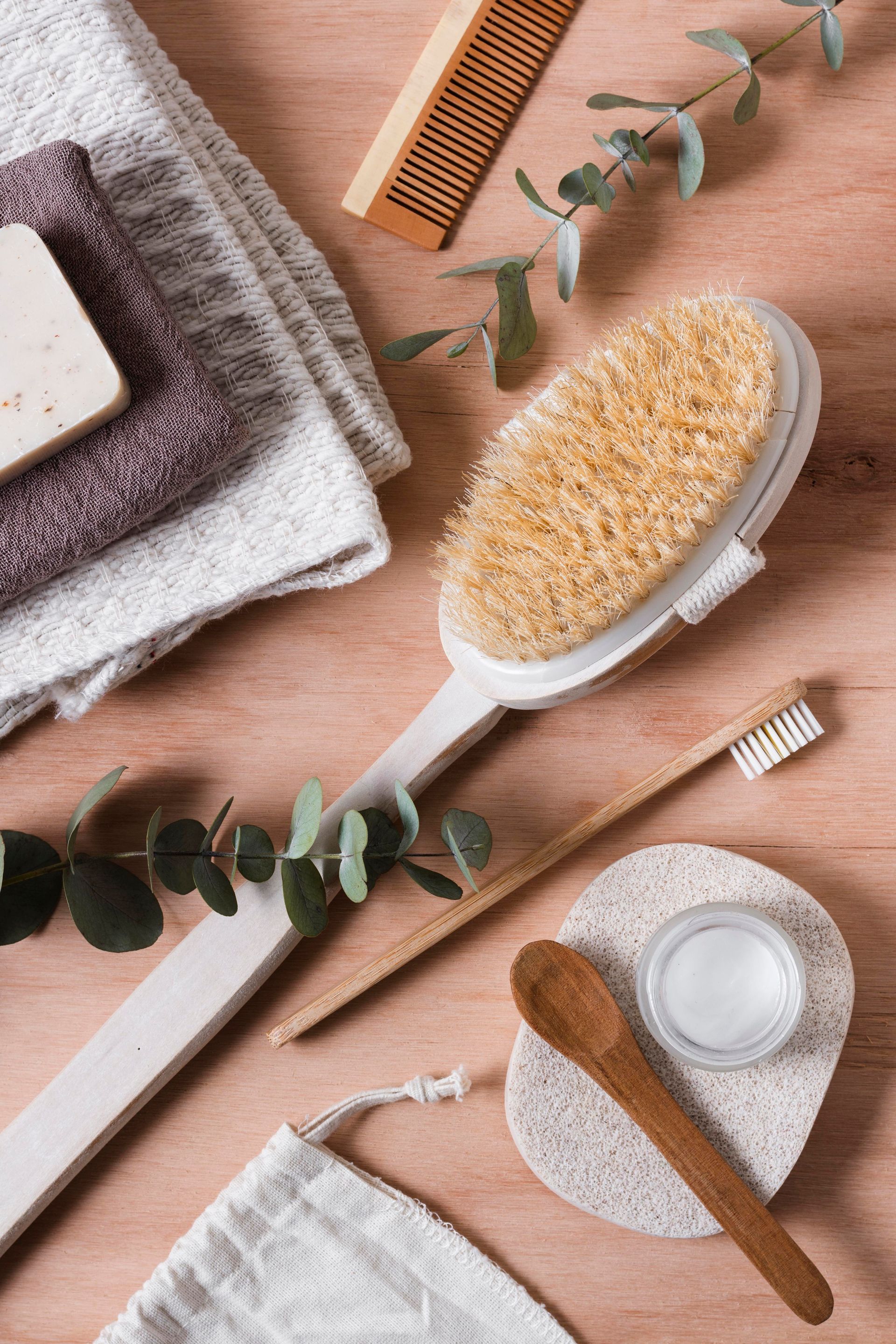 A wooden table topped with a body brush , toothbrush , comb , and soap.