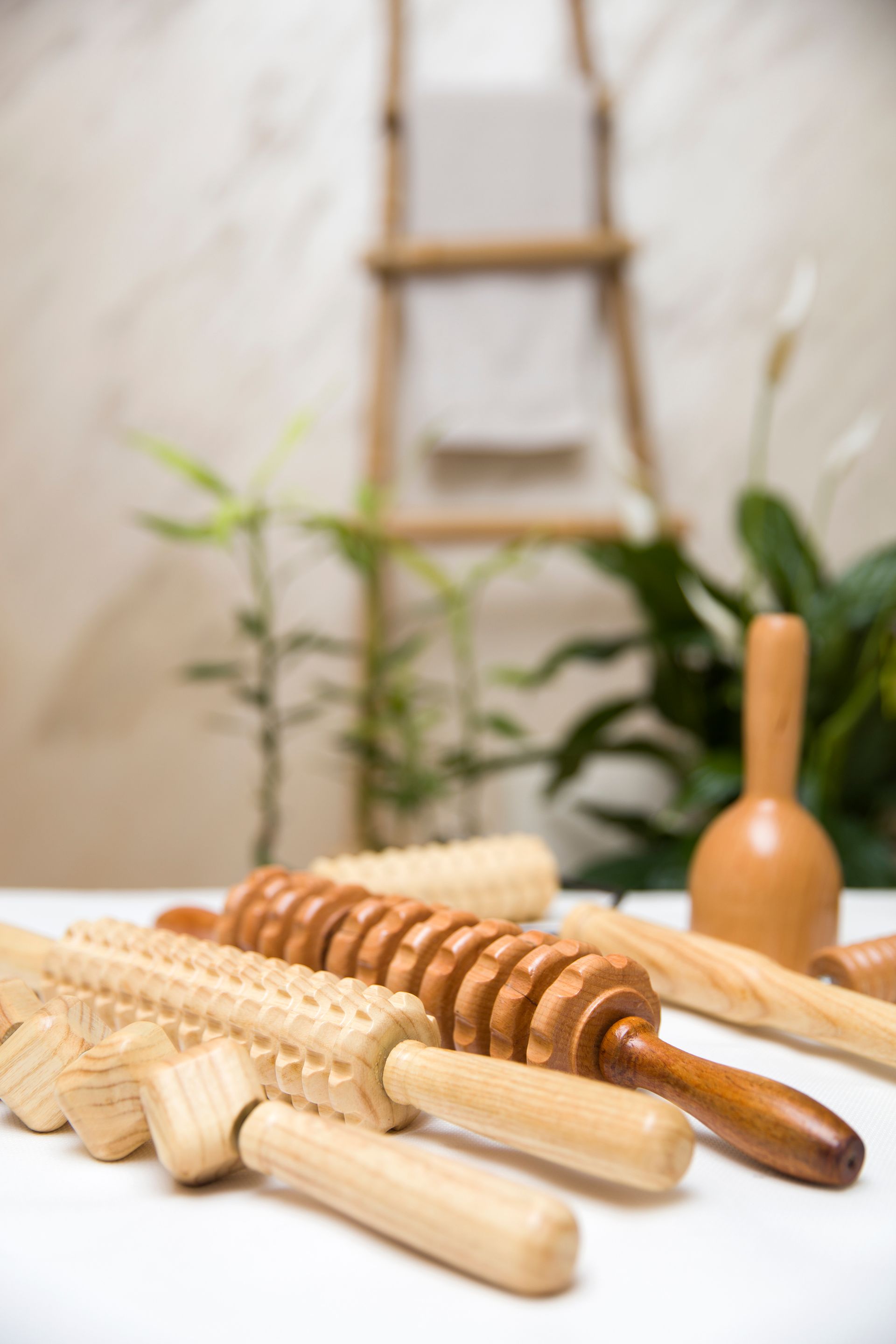 A bunch of wooden massage rollers are sitting on a table.