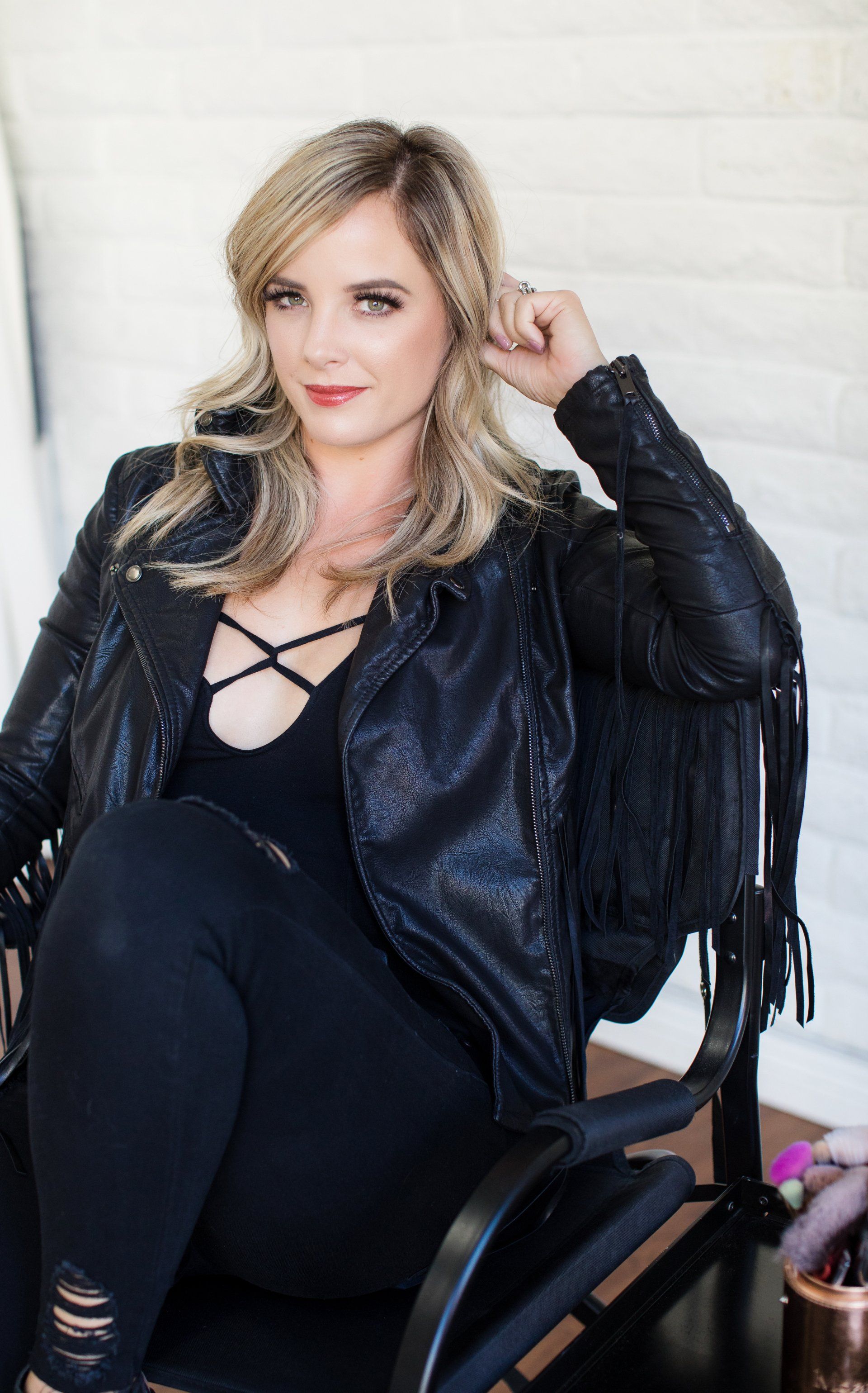 Edgy creative headshot of a woman in a black leather jacket