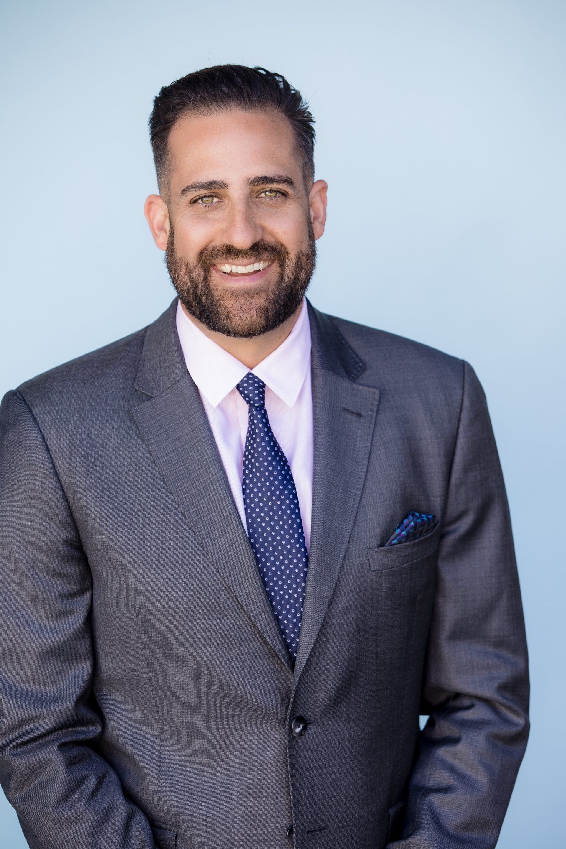 Real estate broker headshot in a grey suit