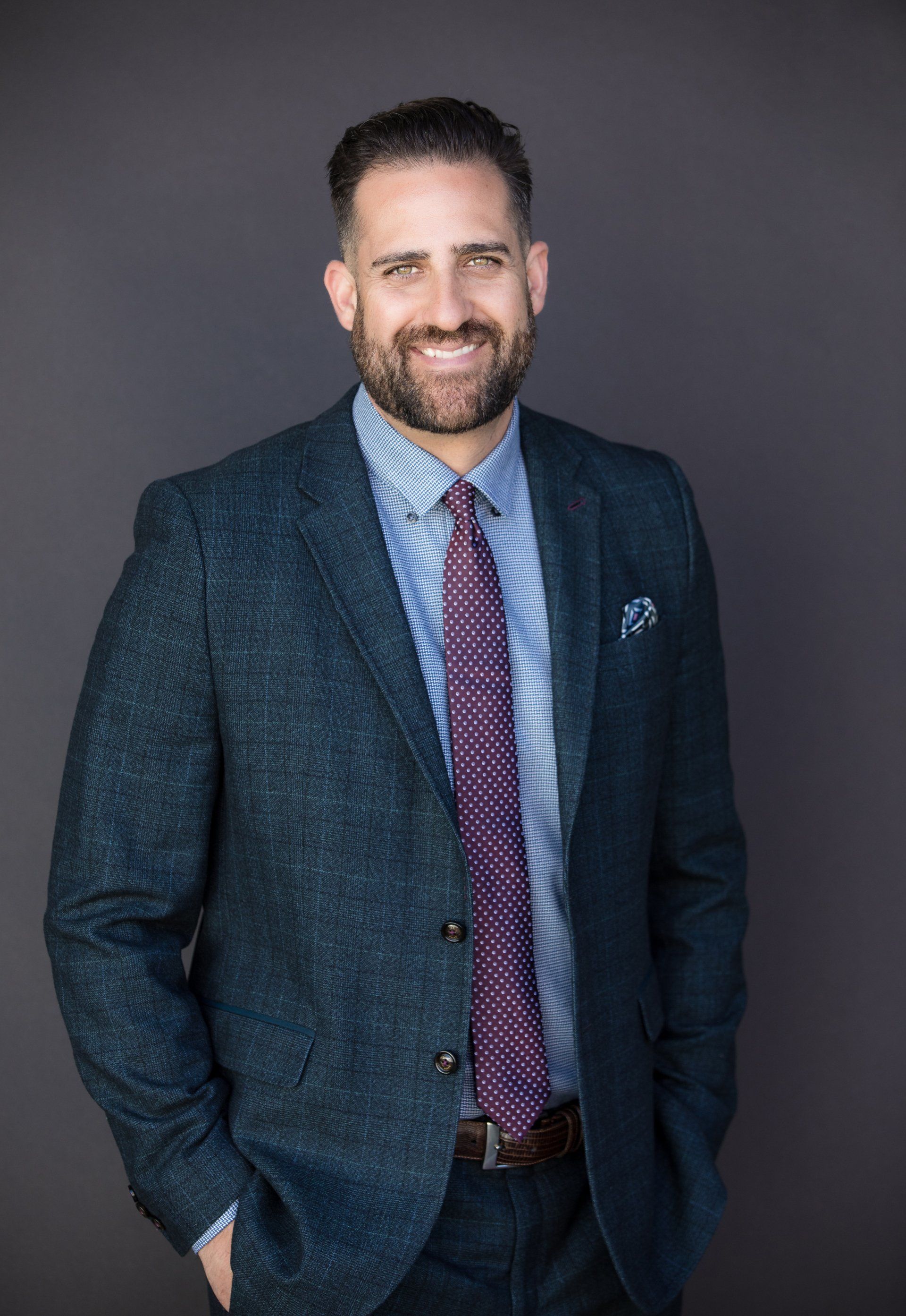 Studio real estate headshot of an agent in a navy suit