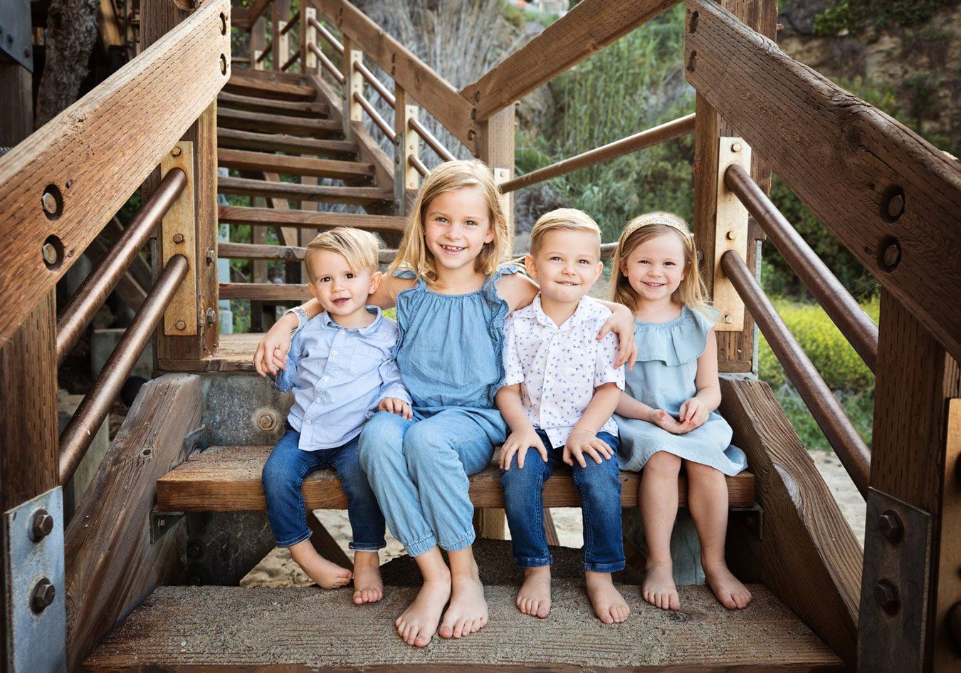 Cousins photographed together on wooden beach stairs in Laguna Beach