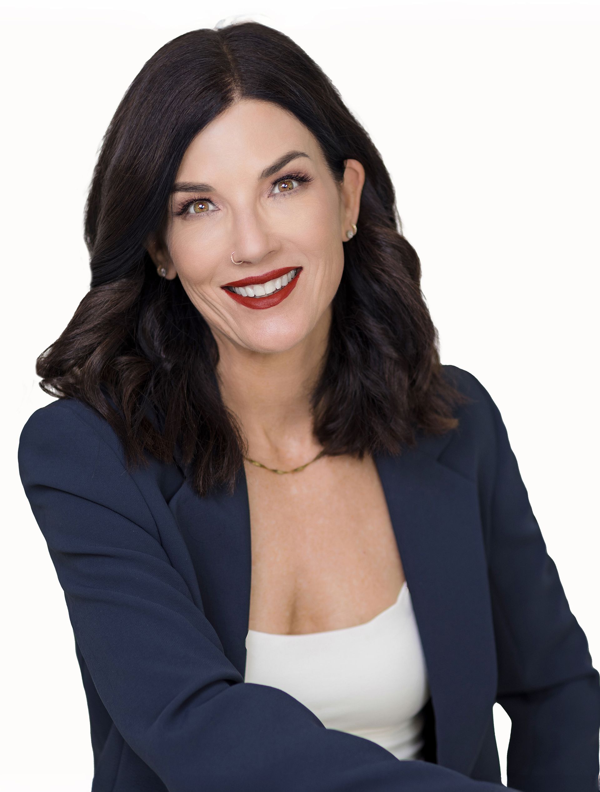 A woman wearing a blue jacket and white top smiles for the camera