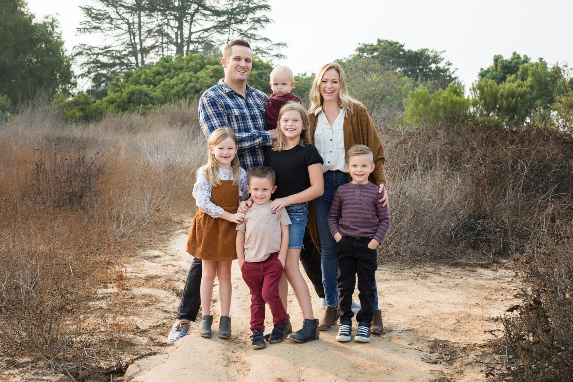 Family of five walking together on a coastal trail in Orange County
