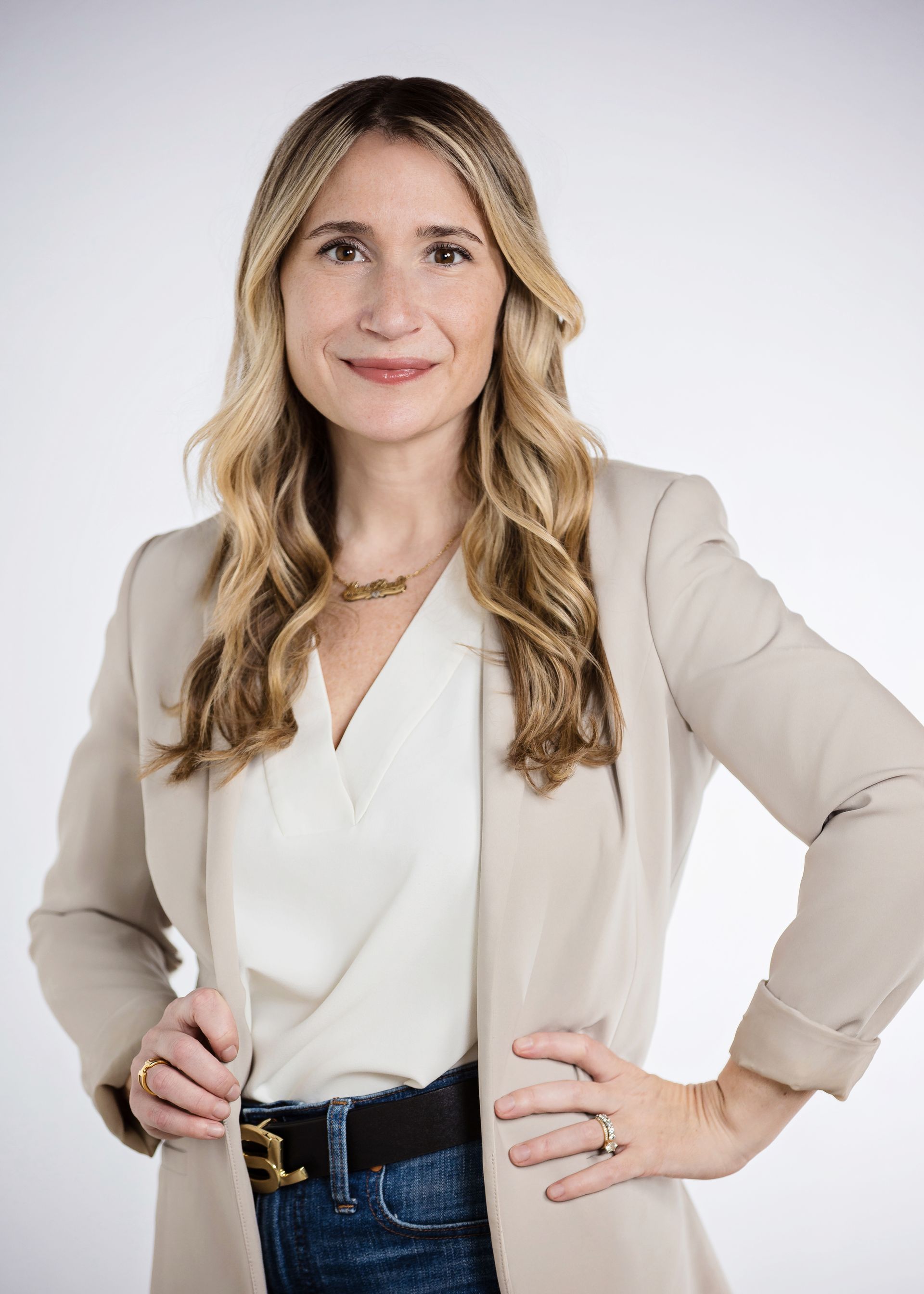Event headshot of a woman in a cream blazer on a white backdrop