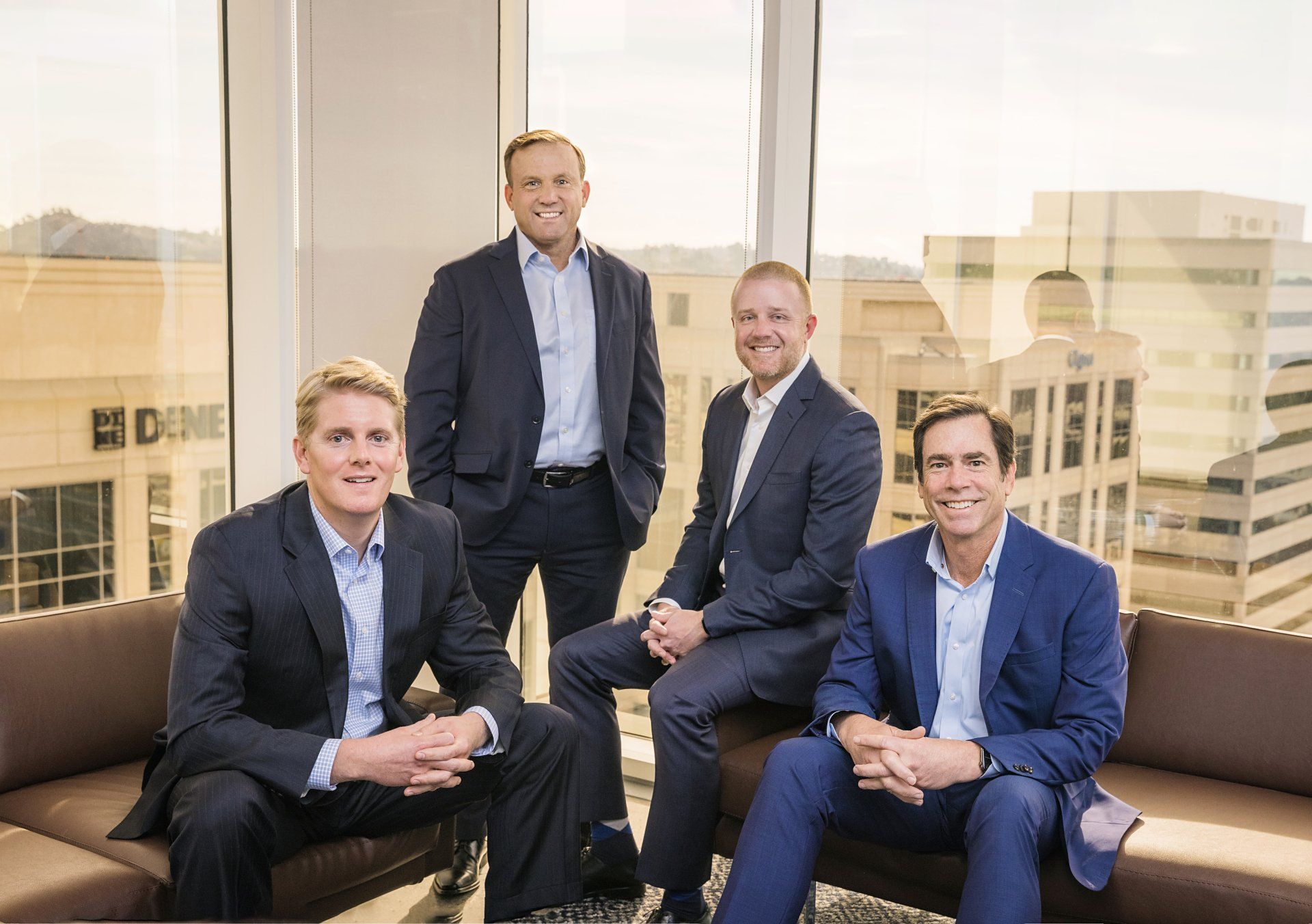 Commercial real estate team seated in an office with city views