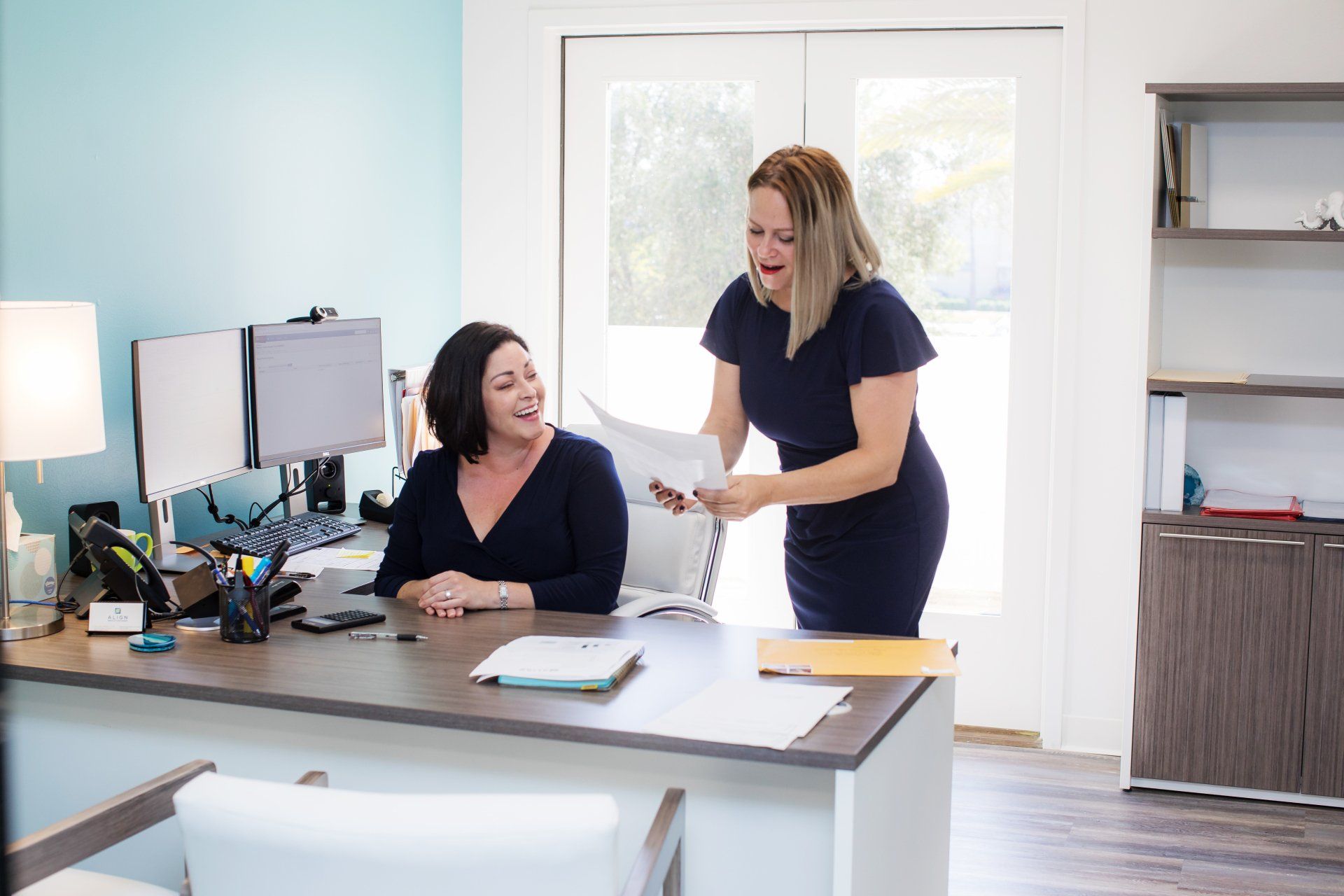 Two financial advisors reviewing work at a desk