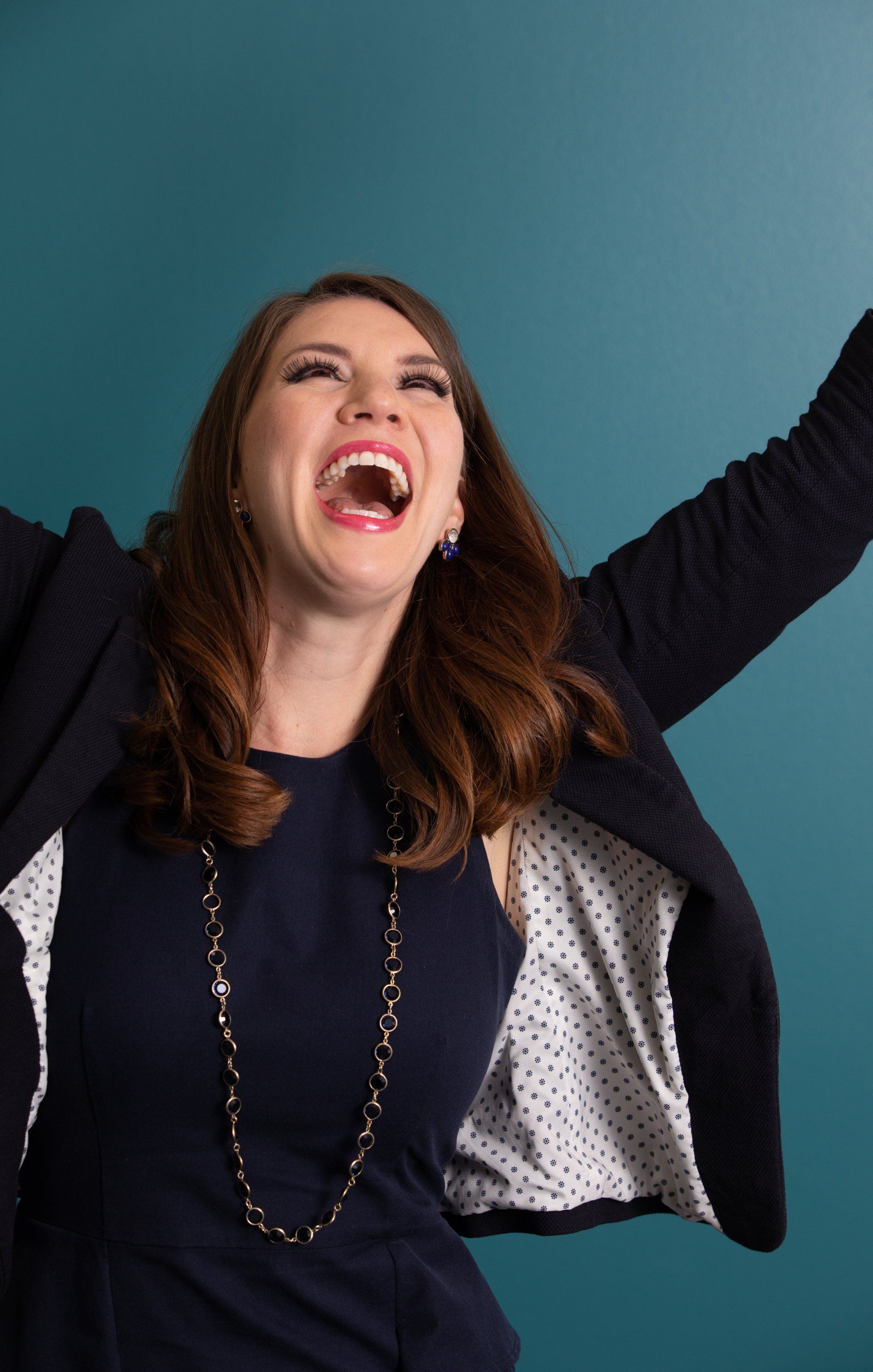 Joyful wealth management headshot on a teal wall