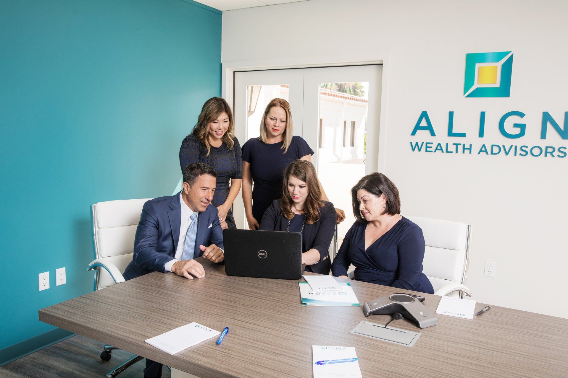 Financial advisors meeting at a conference table in a branded office