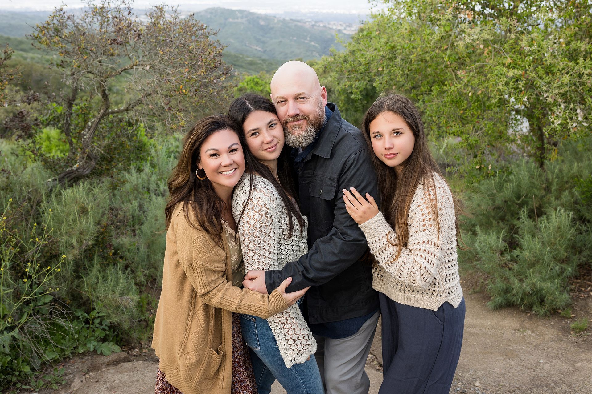 Family hugging on the trails at Alta Laguna Park with canyon views, Laguna Beach