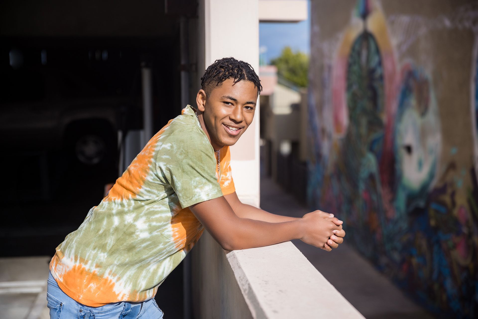 Senior guy leaning on a wall with street art in the Santa Ana Art District