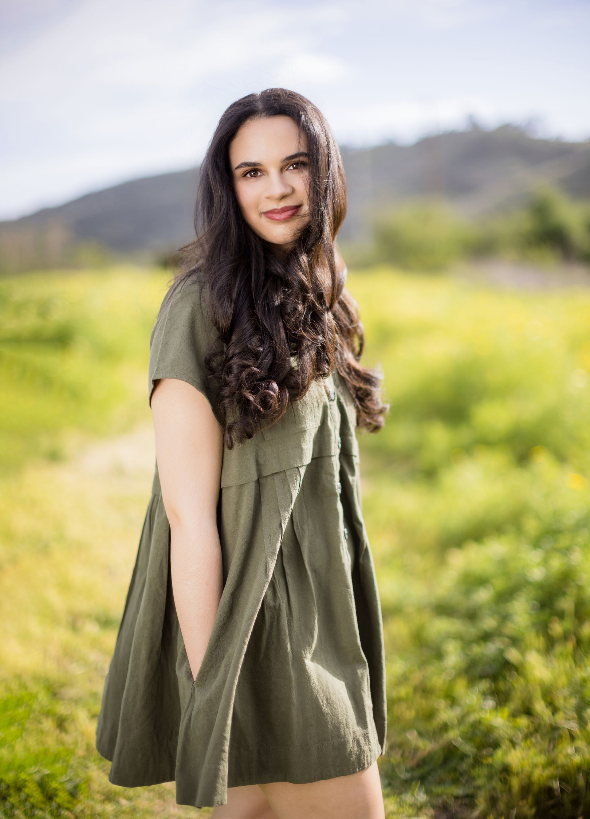 High school senior posing in a scenic field in Orange County, showcasing natural beauty and personal style