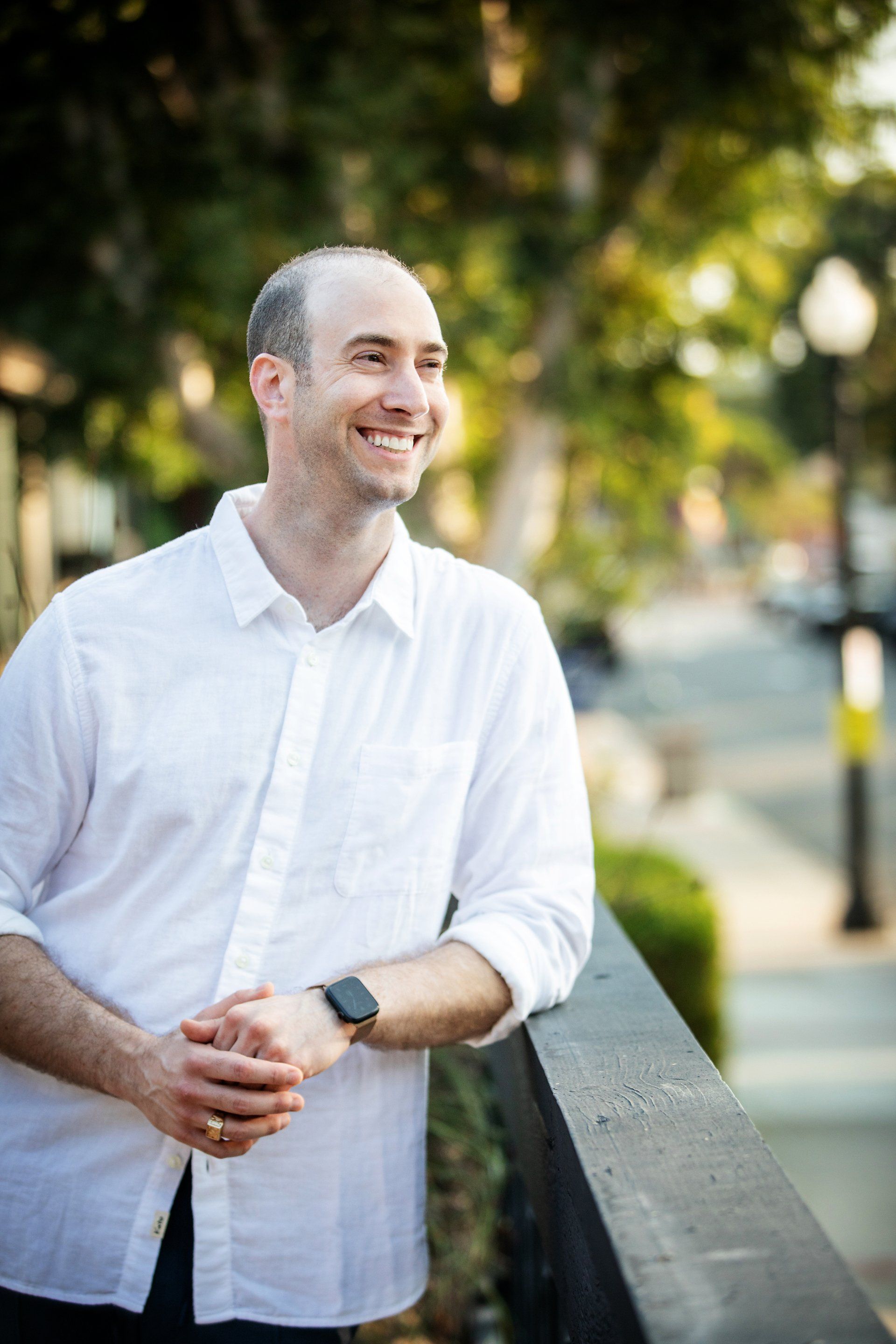 Smiling lifestyle portrait of a man in a white shirt outdoors