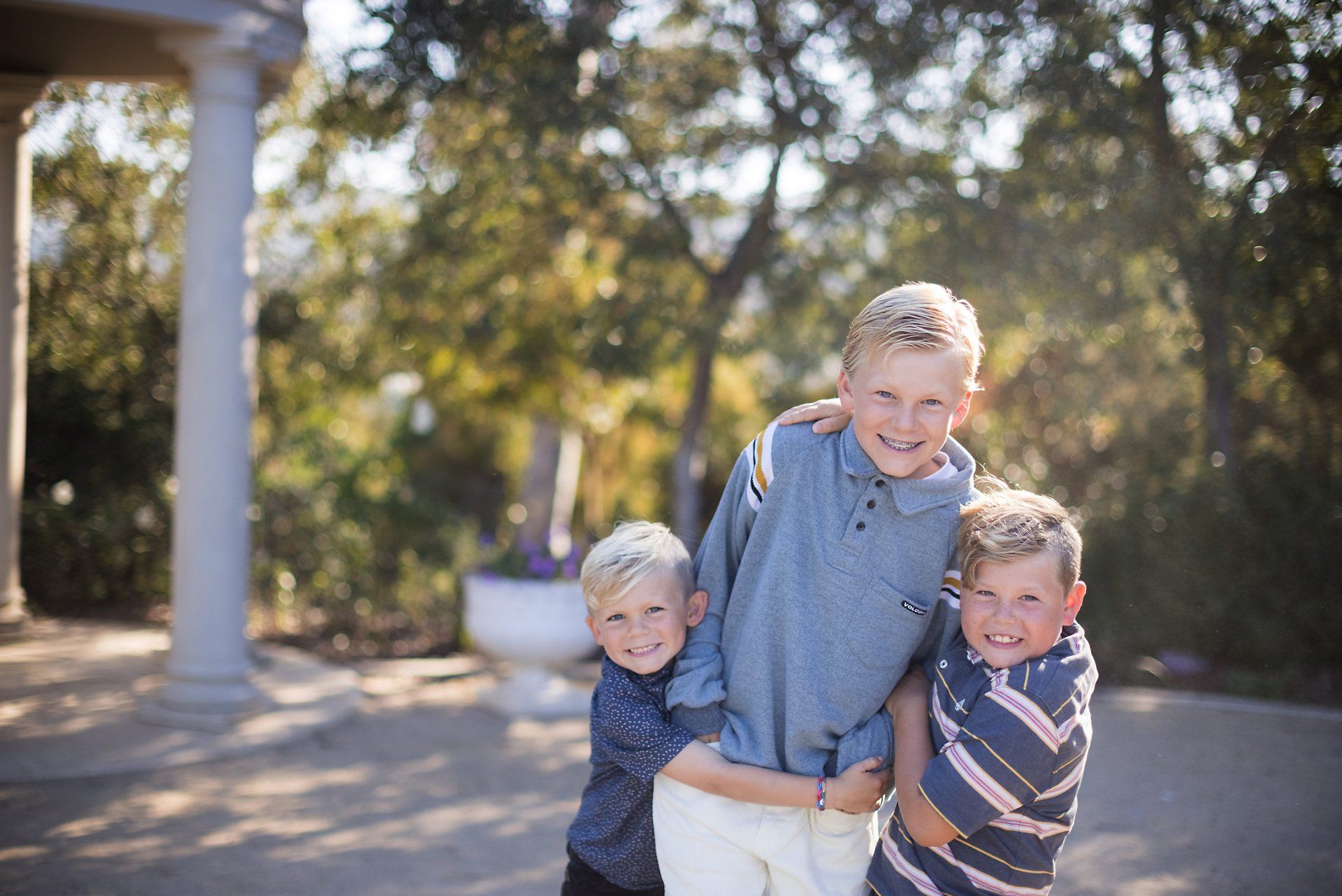 Three young boys are posing for a picture together.