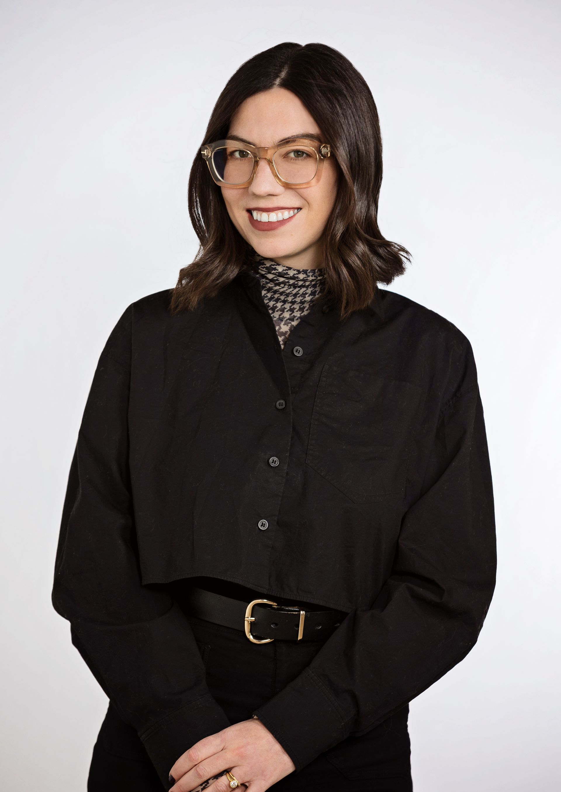 A woman wearing glasses and a black shirt is smiling for the camera.