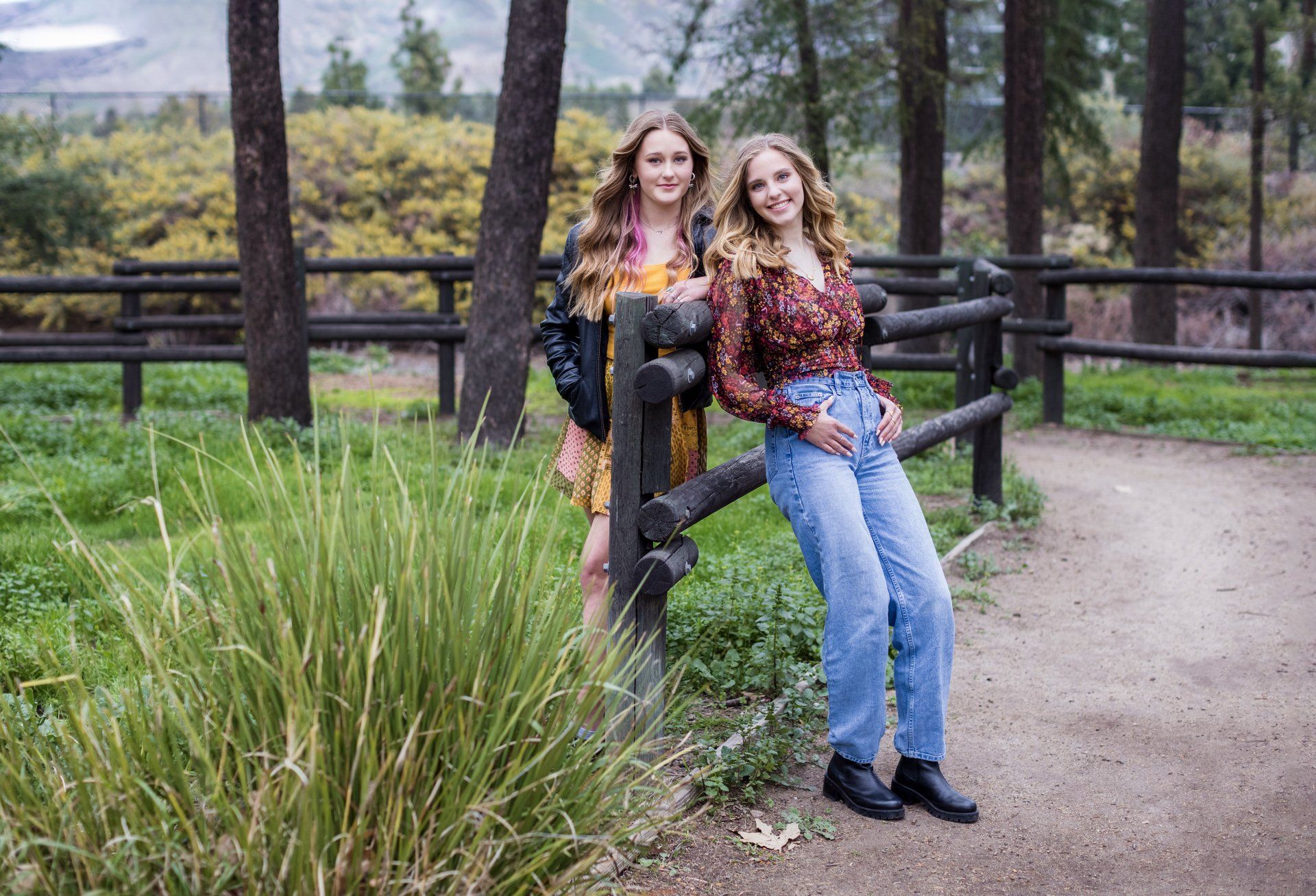 Two sisters by a split-rail fence among the cedars at Cedar Grove Park, Tustin