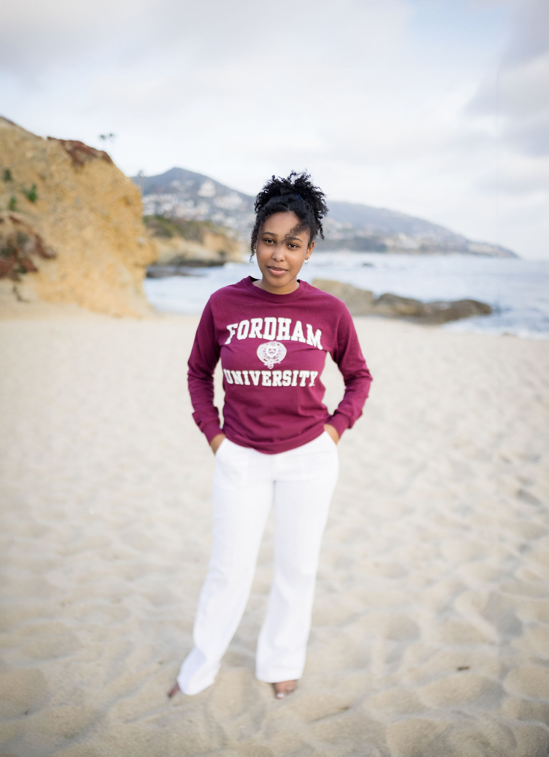 Senior girl in a college sweatshirt on the sand at Treasure Island