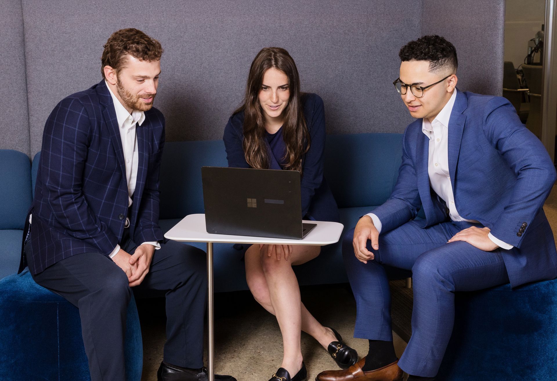 Corporate branding photo of a team collaborating around a laptop in an Orange County office