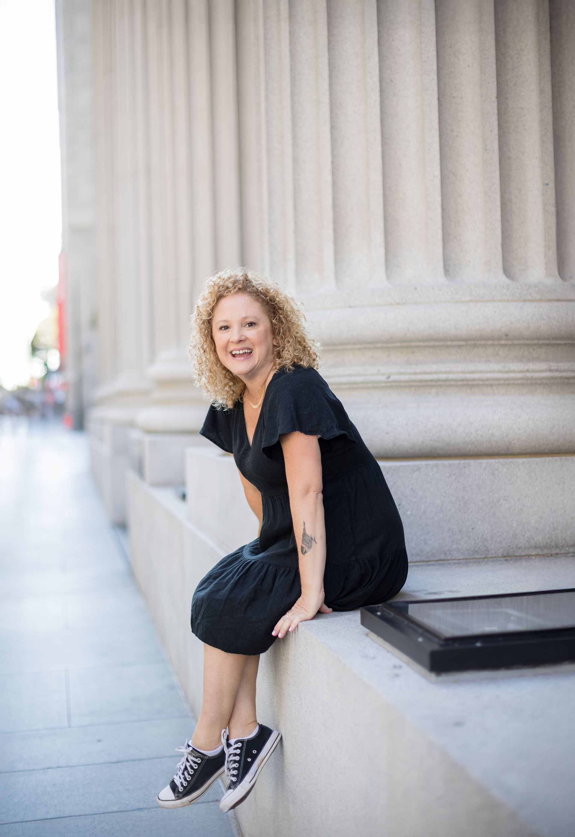 Creative professional branding portrait seated by columns in Orange County