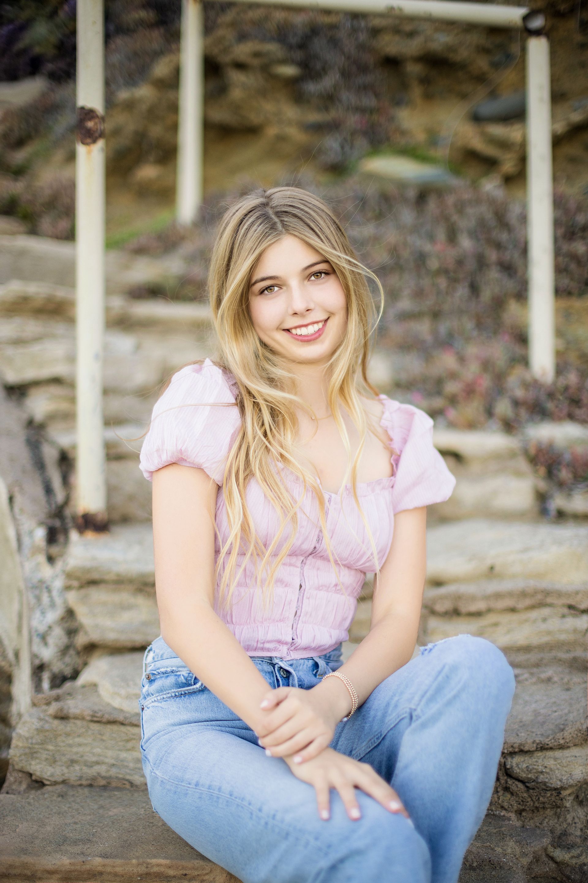 Senior girl seated on the old stairs at Crescent Bay