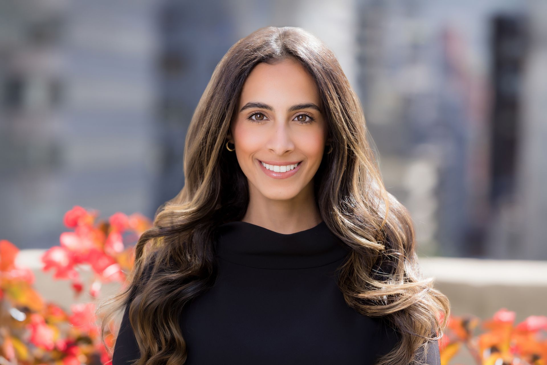 A woman with long hair is smiling for the camera while wearing a black shirt.