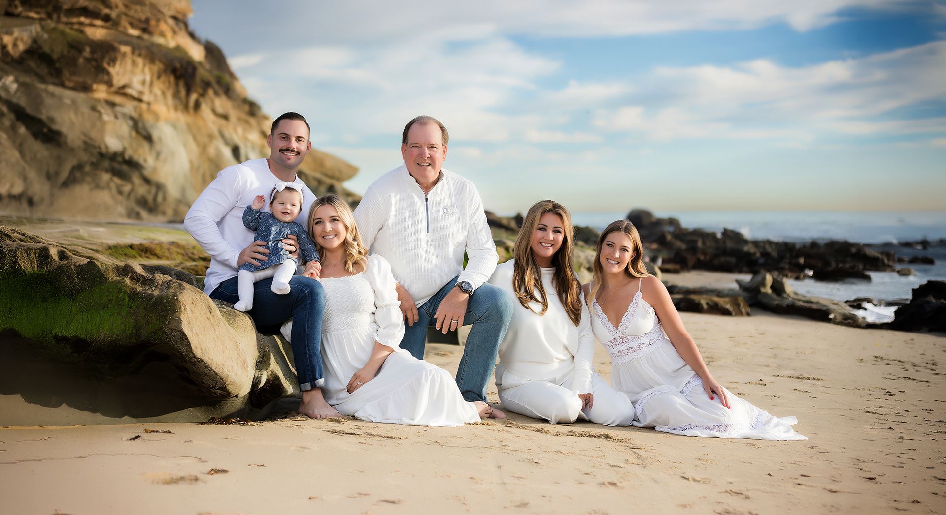 Grandparents with their children and grandchildren on the rocks at golden hour, Laguna Beach