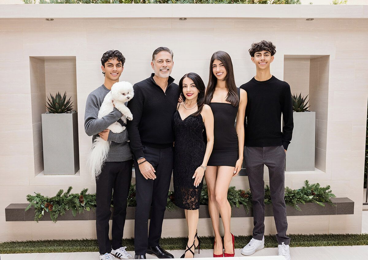 tylish family dressed in black and gray, posing in front of their elegant Newport Coast home, captured by a premier Orange County photographer.