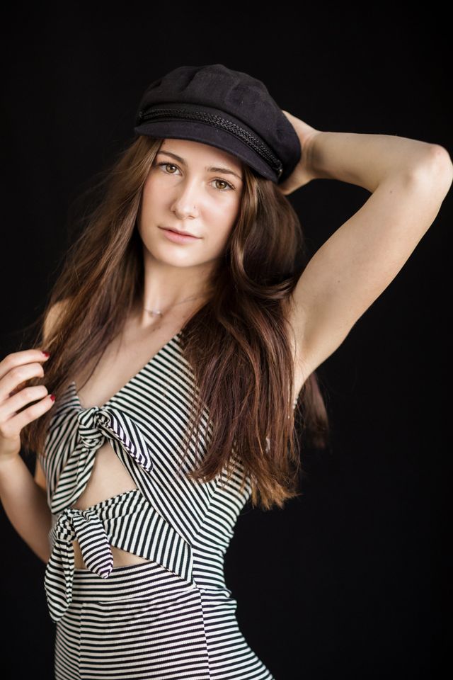 Senior girl in a newsboy cap on black, our Laguna Beach studio