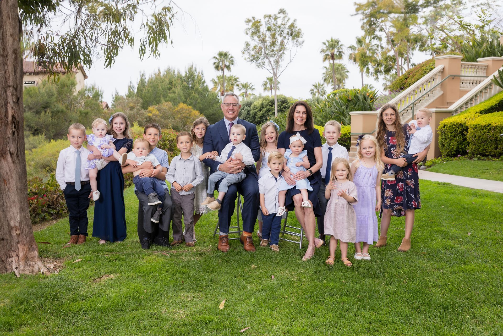 Large extended family portrait with grandparents and many grandchildren on a lawn at Newport Coast by a Laguna Beach family photographer
