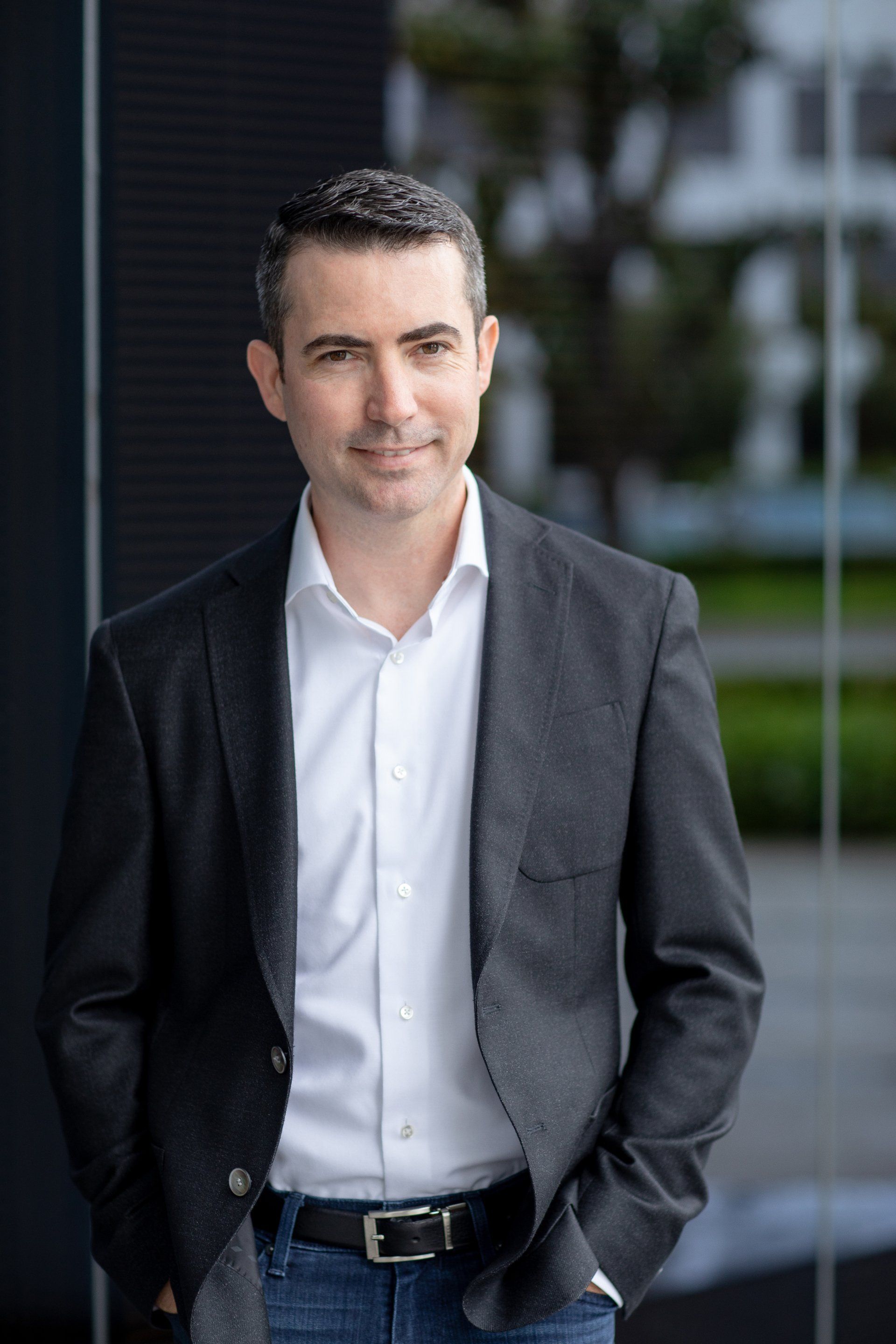 Insurance agent headshot in a dark blazer outdoors