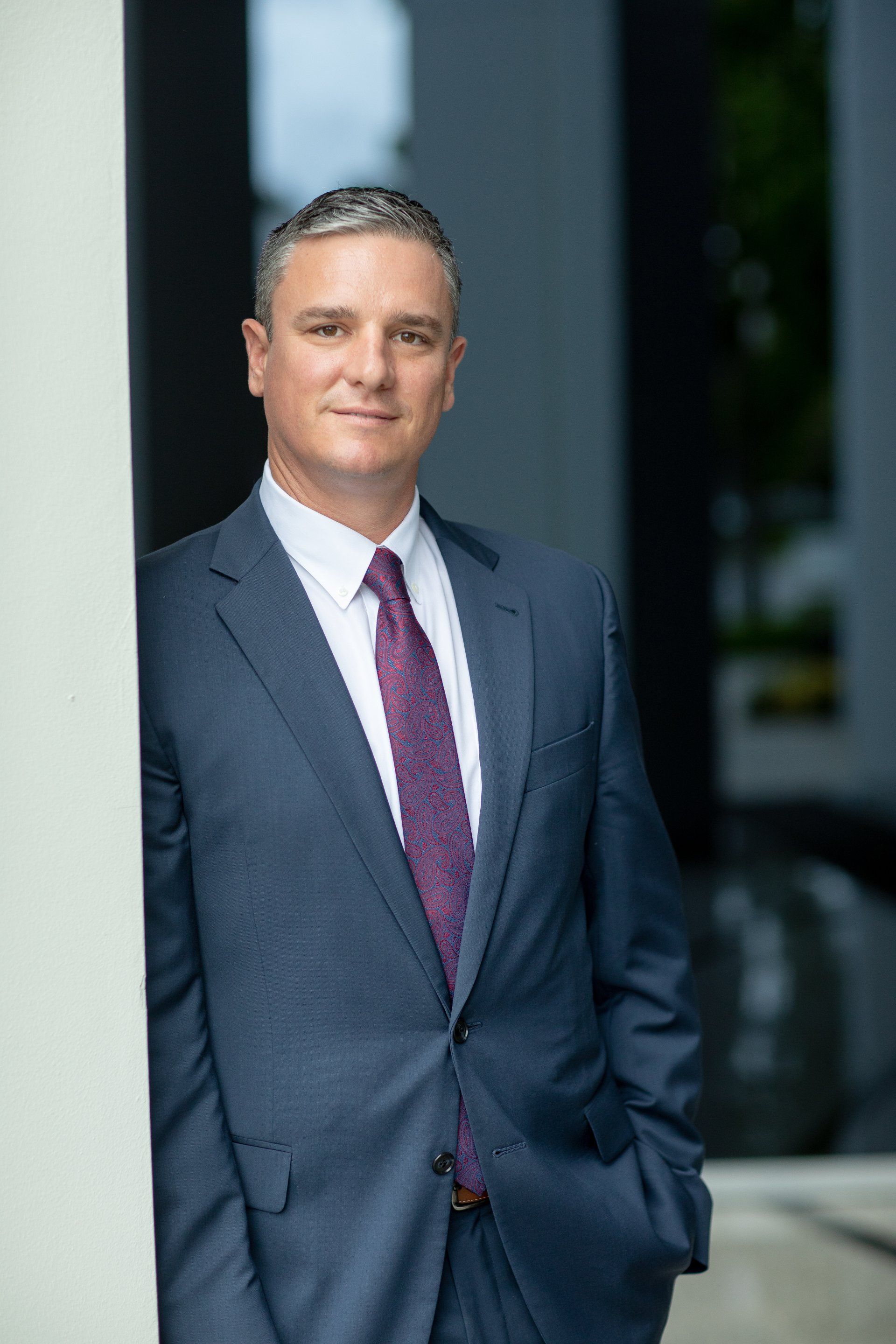 Financial advisor headshot in a charcoal suit and burgundy tie