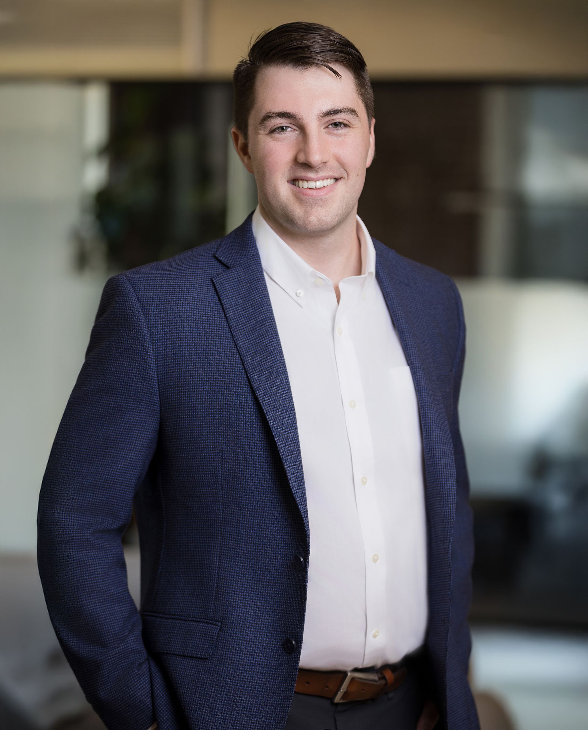 A man in a suit and white shirt is smiling for the camera.