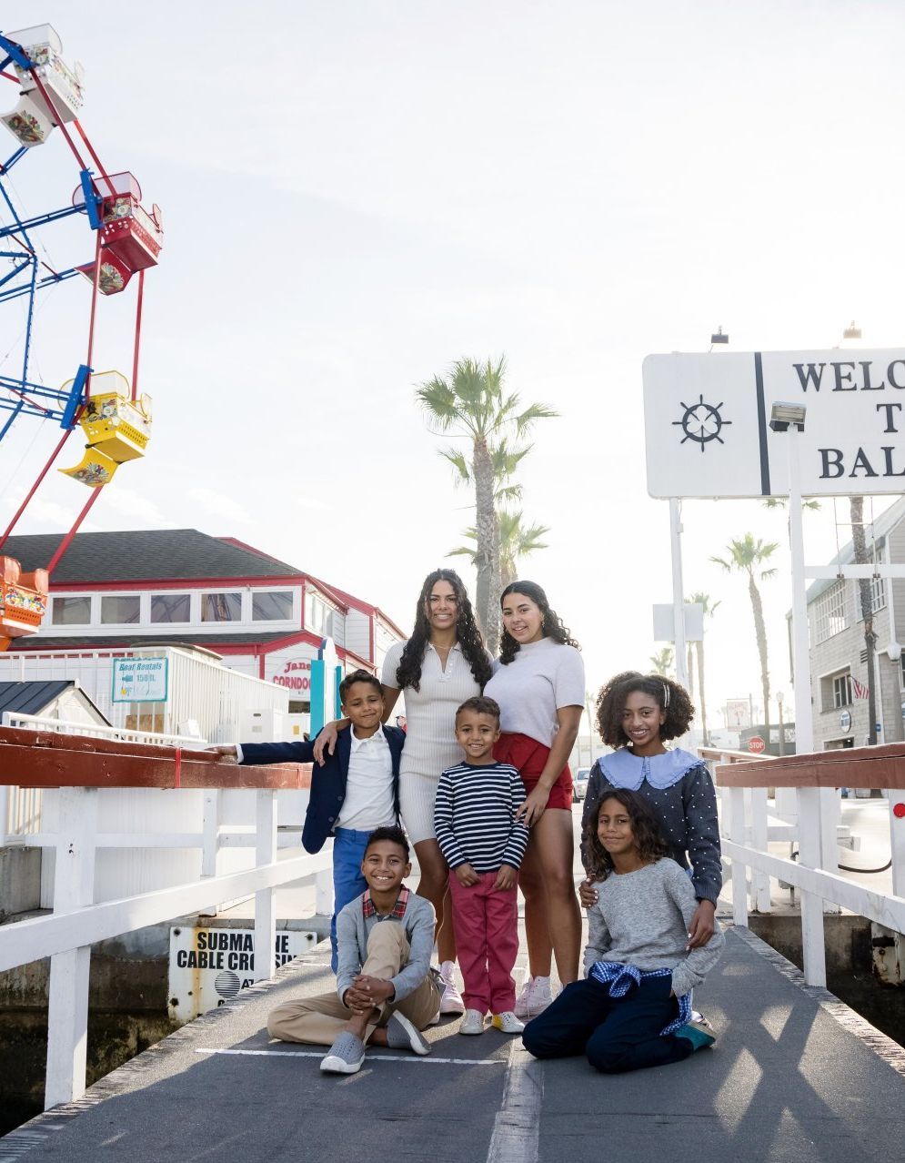A group of people are posing for a picture in front of a ferris wheel.