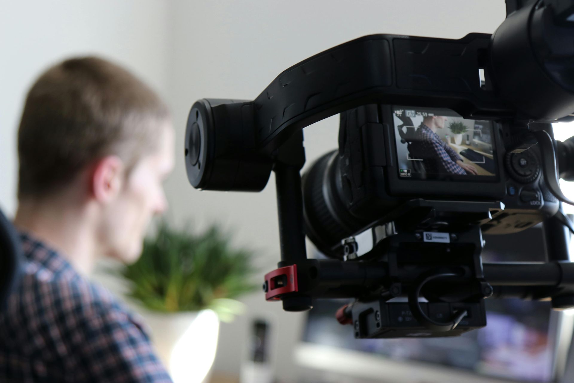 A man is sitting in front of a video camera