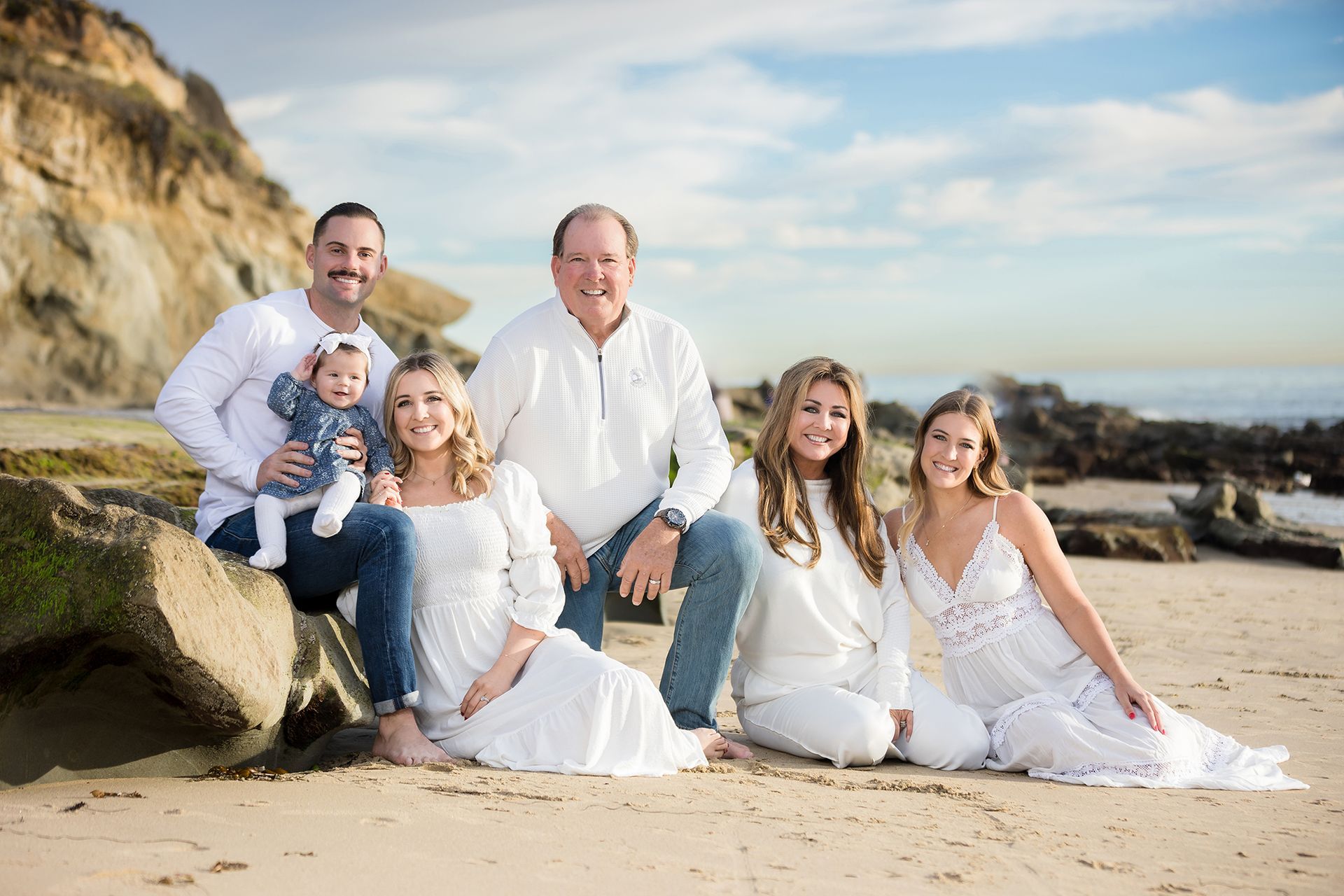 A family is posing for a picture on the beach.