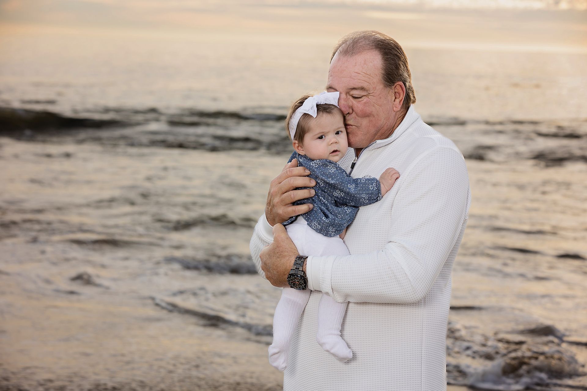 grandfather posing with his baby granddaughter at sunset in Laguna Beach