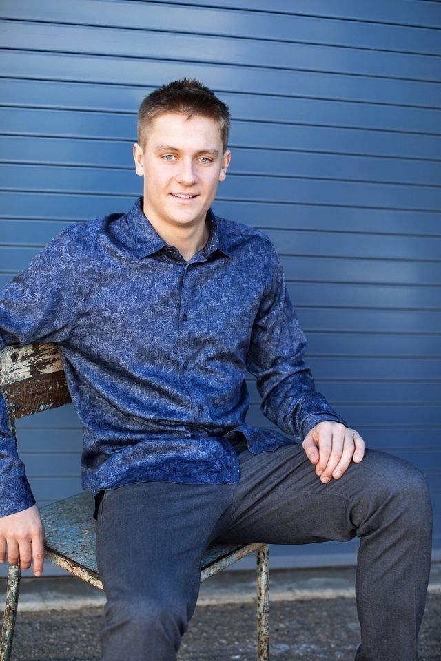 Senior guy seated on a blue wall, our Laguna Beach studio