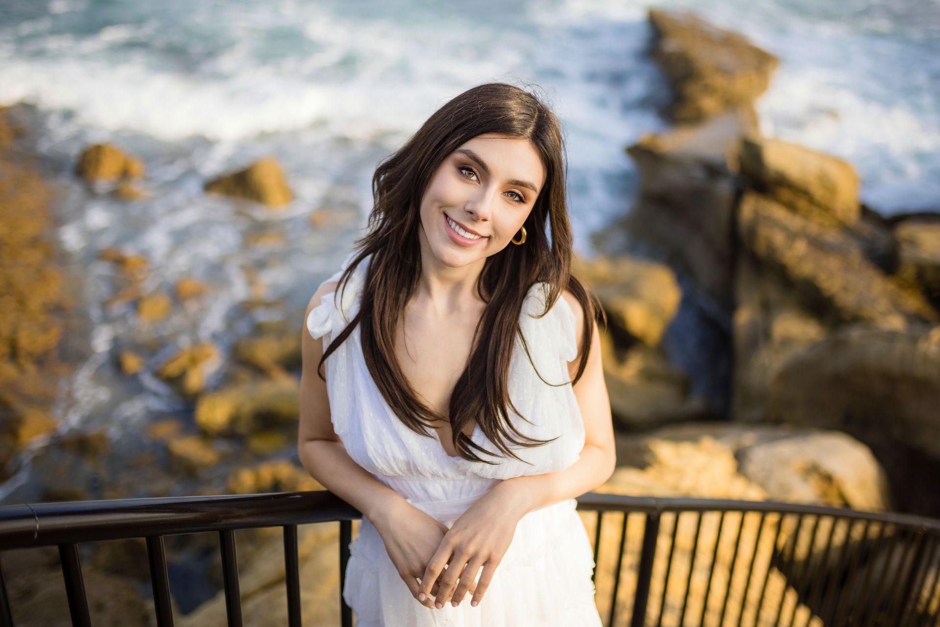 Senior portrait by the ocean railing at Heisler Park