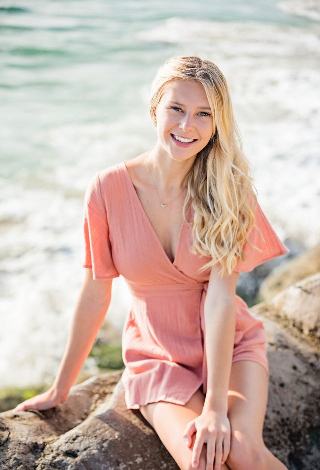 Senior girl in coral on the rocks, Laguna Beach