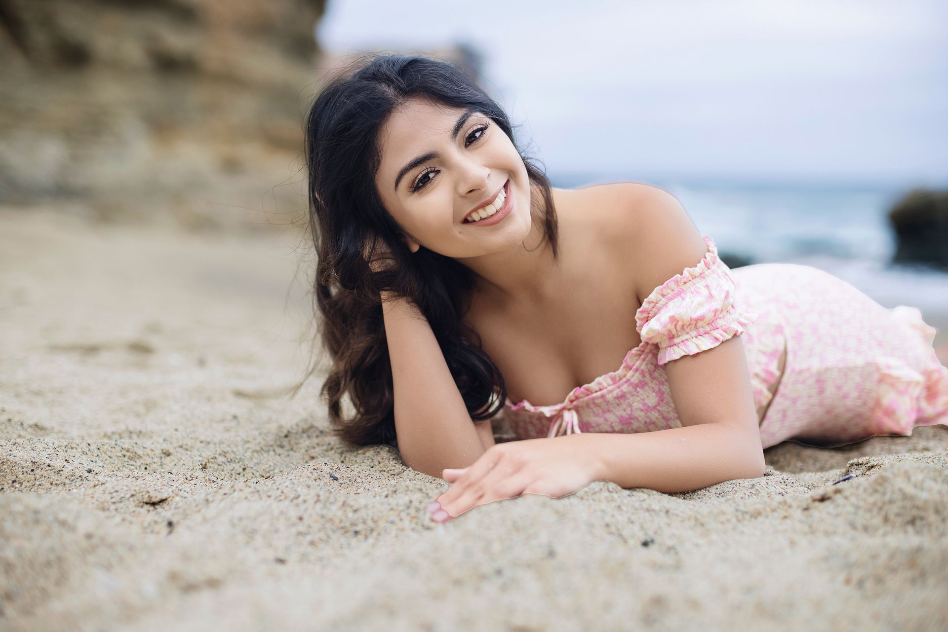Smiling senior girl lying on the sand in South Laguna