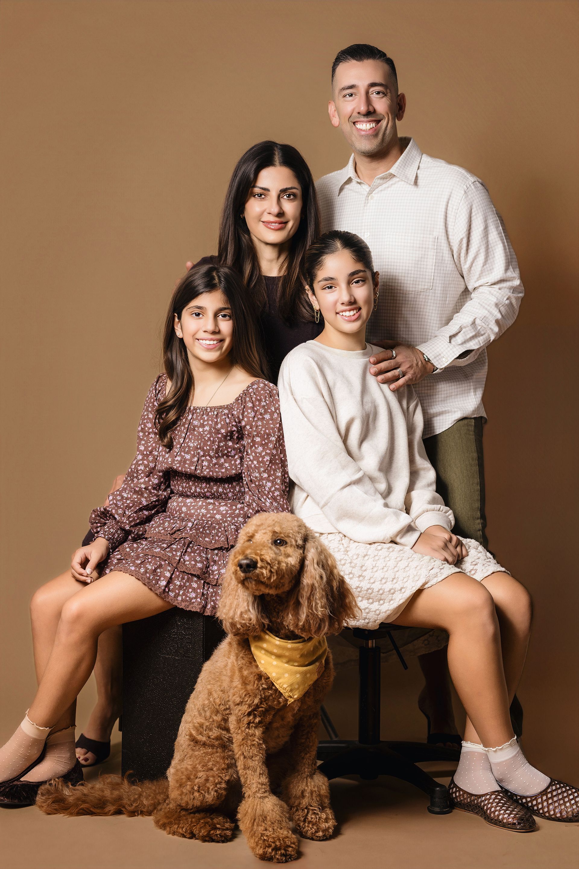 Family portrait with their dog on a warm brown backdrop in our Laguna Beach studio