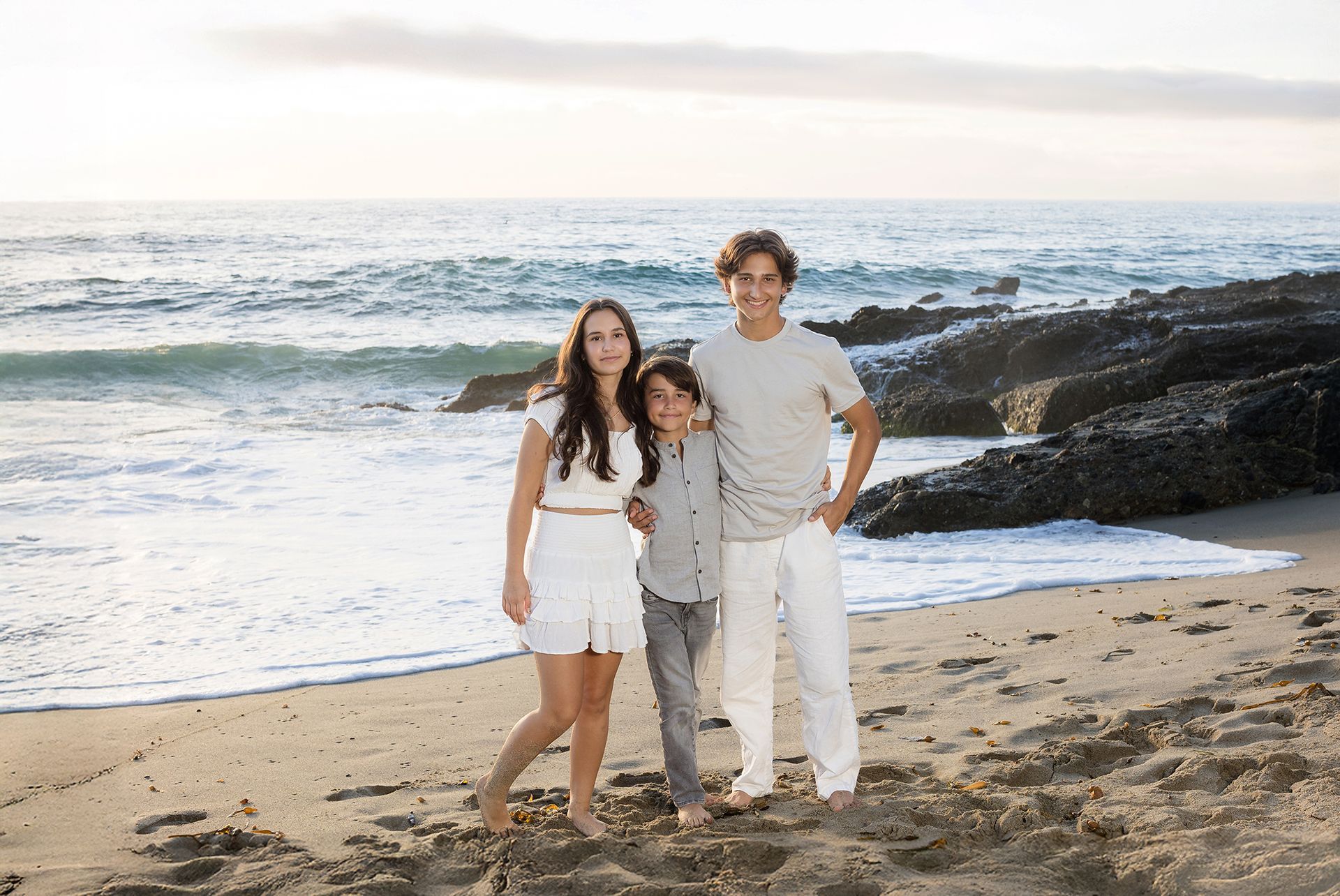 Siblings by the ocean during a golden hour Laguna Beach session by an Orange County photographer.