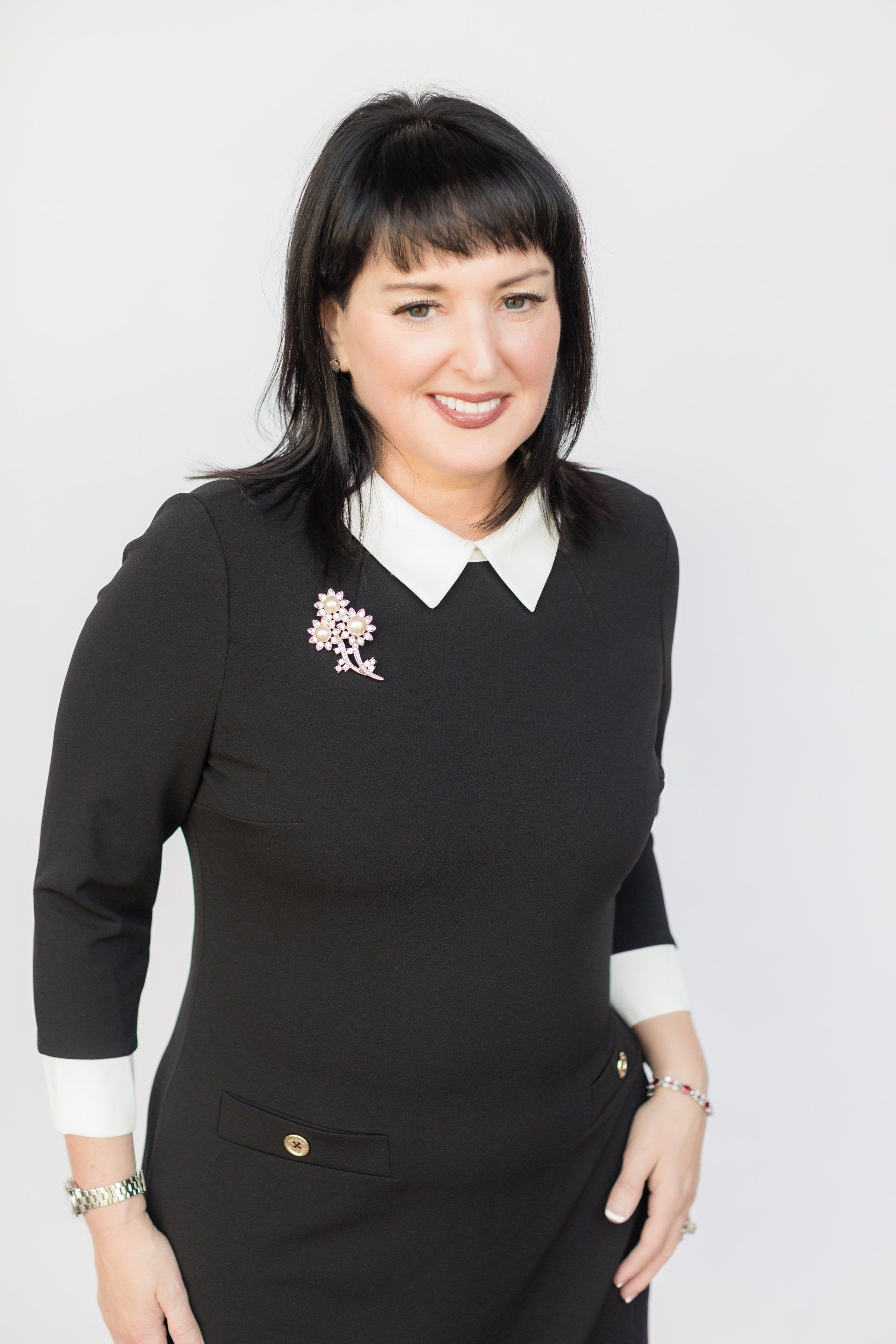 CPA headshot in a black dress with a white collar