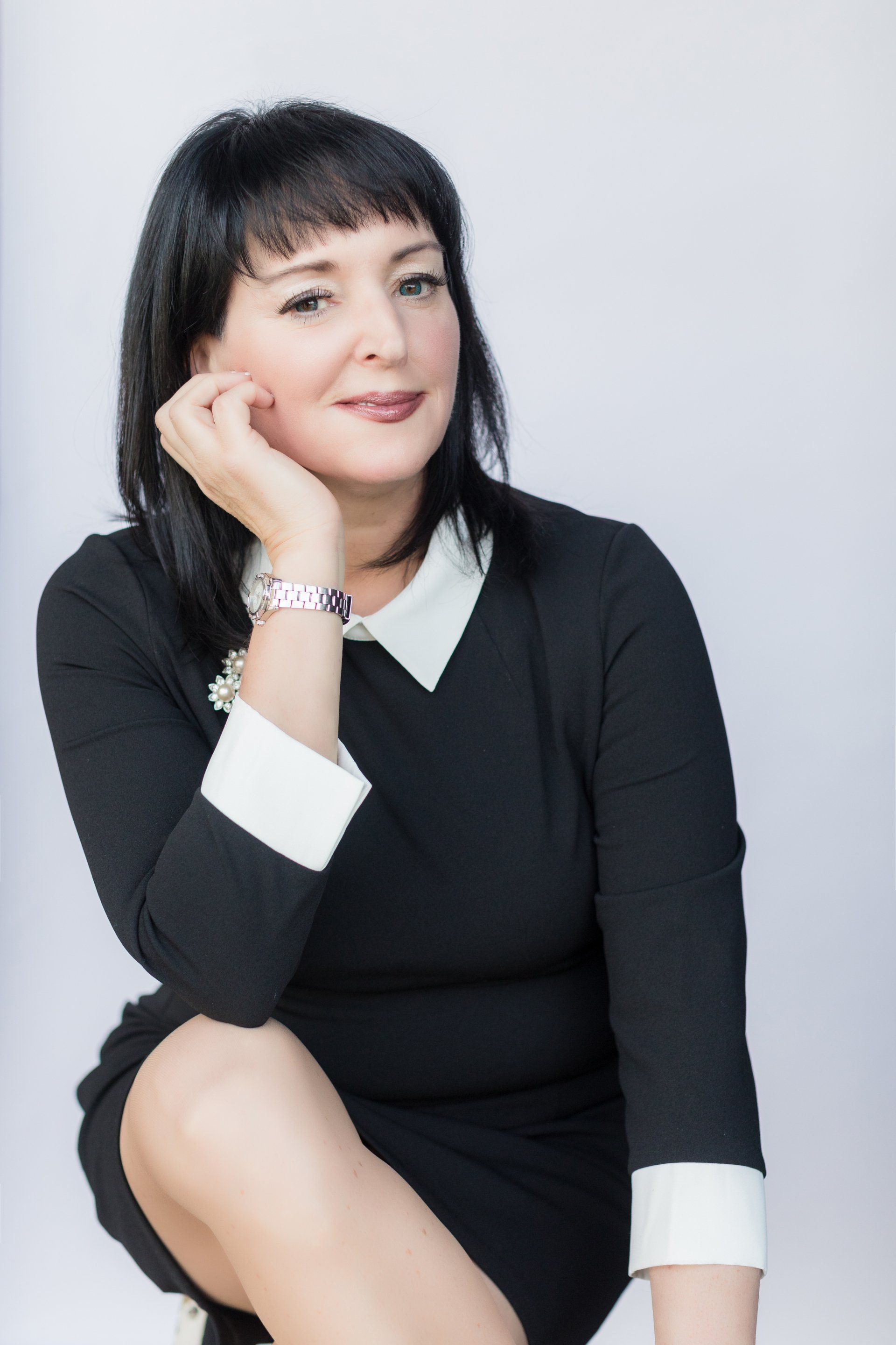 Tax specialist headshot seated on a white backdrop