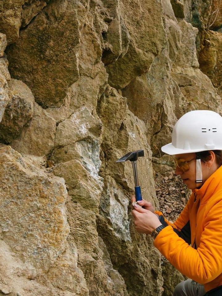 a person wearing a white hard hat is holding a hammer