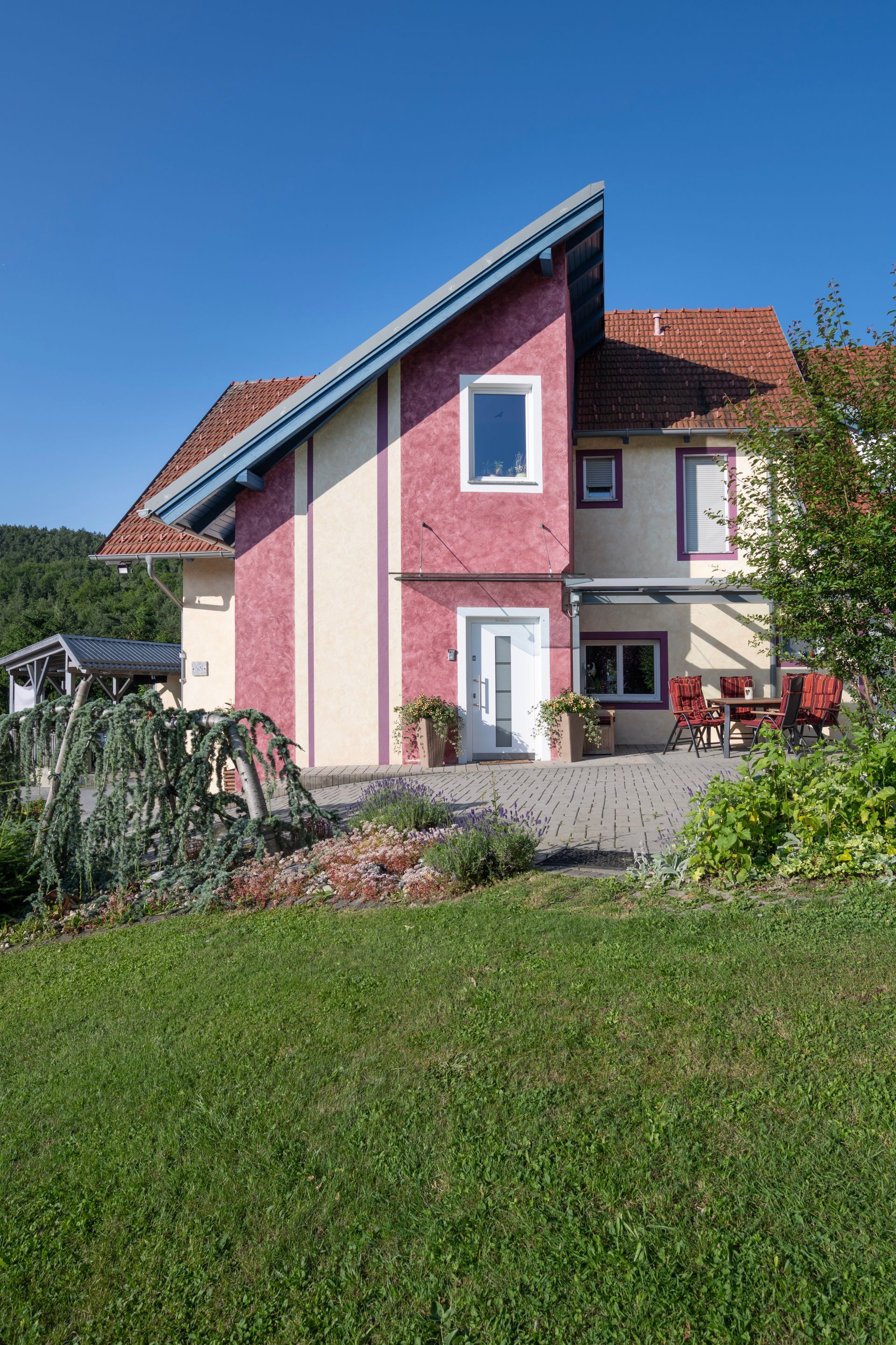 ein rosa und weißes Haus mit einem blauen Dach