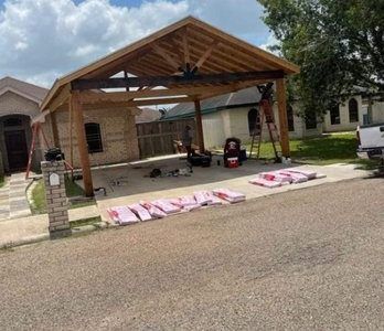 Covered driveway with pink signs or posters laid on the ground in front of a house