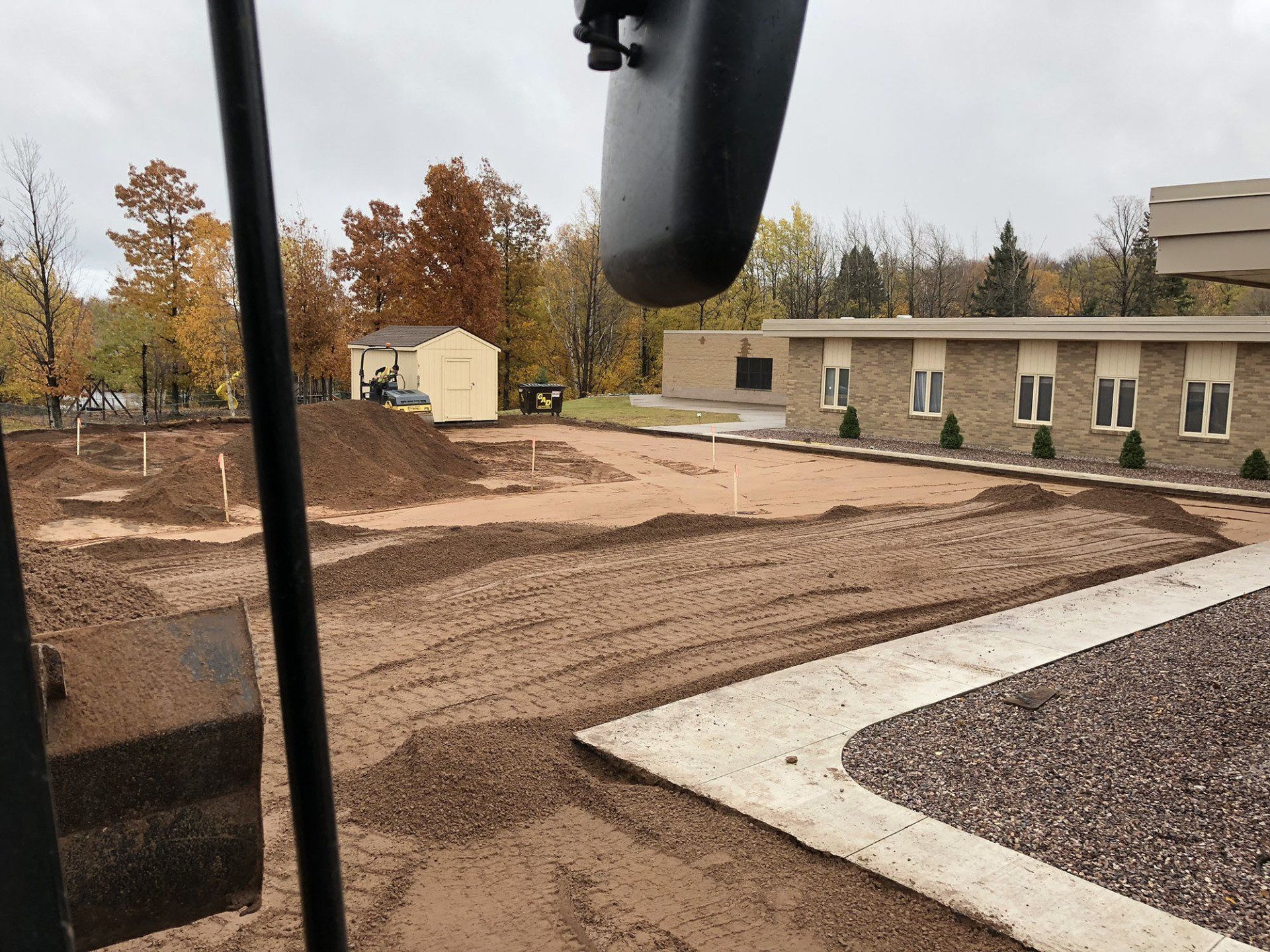 A large pile of dirt is in front of a building
