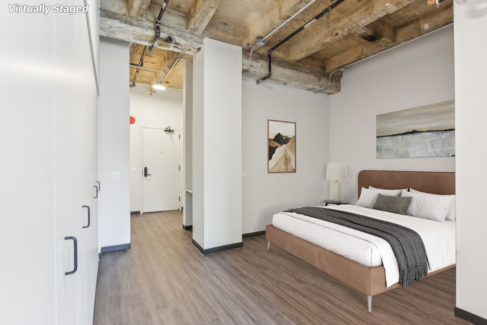 A bedroom with a large bed and wooden floors