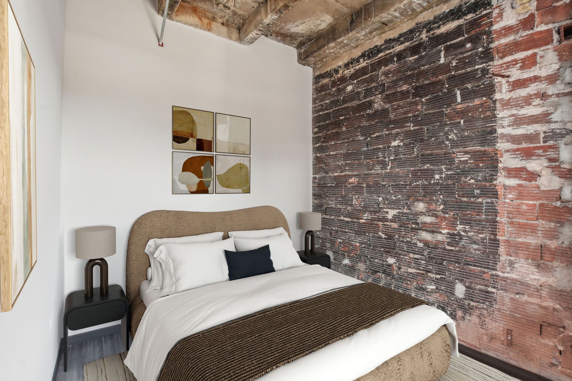 A bedroom with a bed and a brick wall.